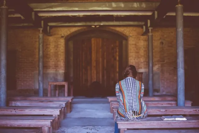 Person sitting quietly in a simple chapel