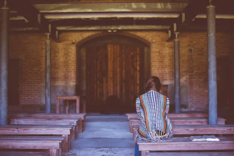 Person sitting quietly in a simple chapel