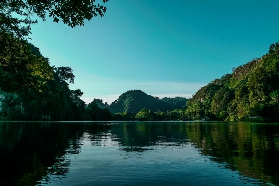 Calm river between green hills reflecting the sky